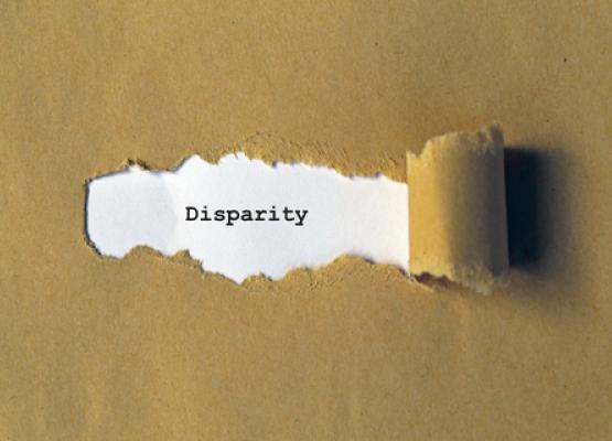 Image of brown paper being ripped back to reveal the word 'disparity'