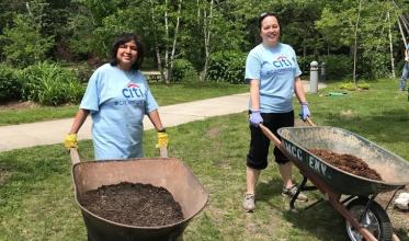 Two women working in the garden with wheelbarrows 